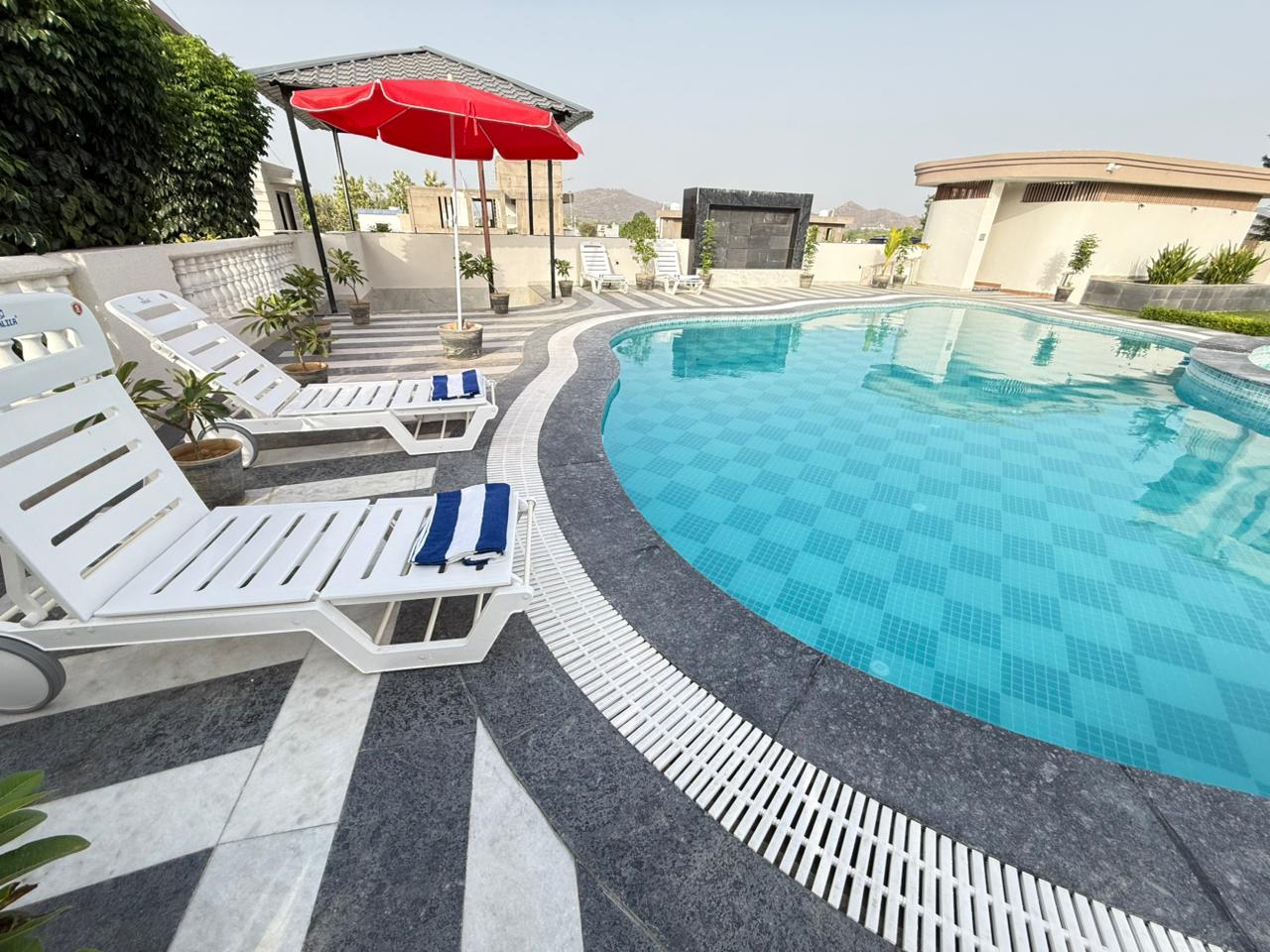 Poolside loungers beneath a red parasol